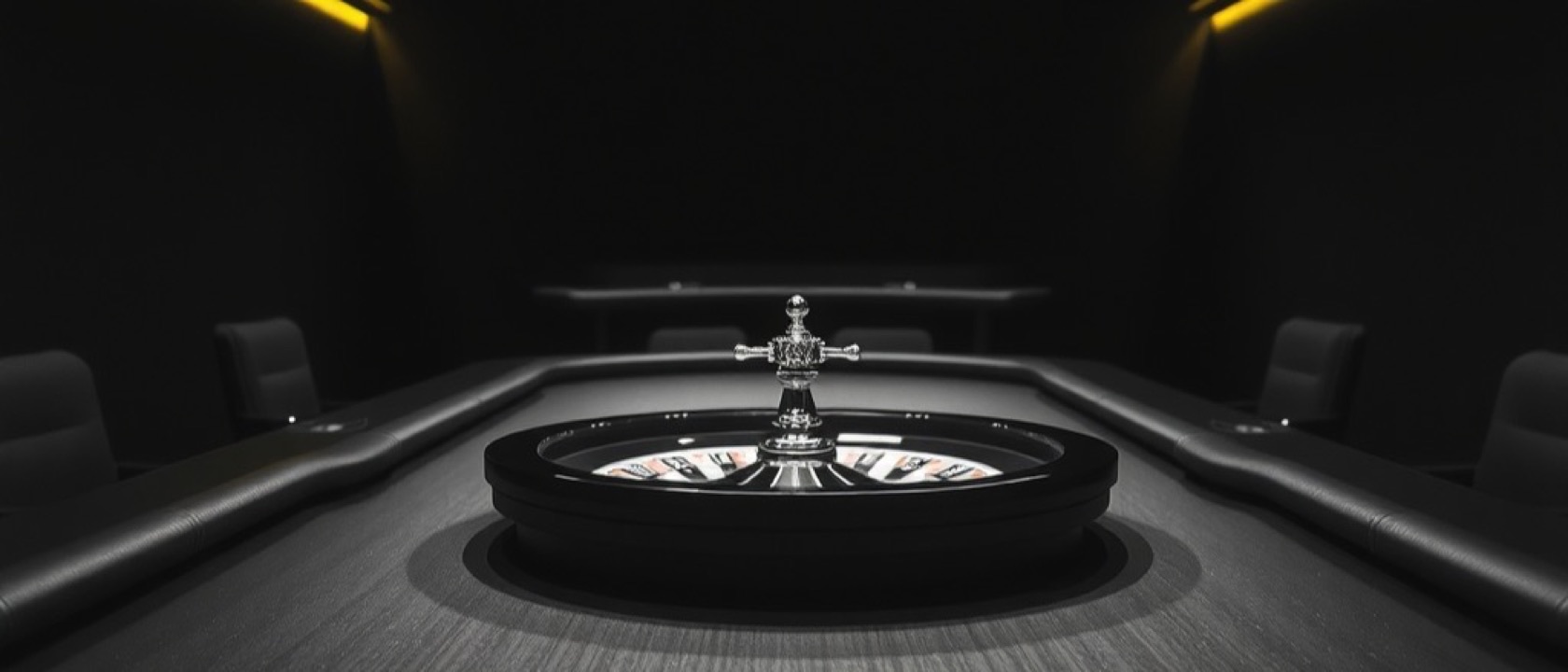 A long gaming table with chip stacks and a roulette wheel receding into the dark